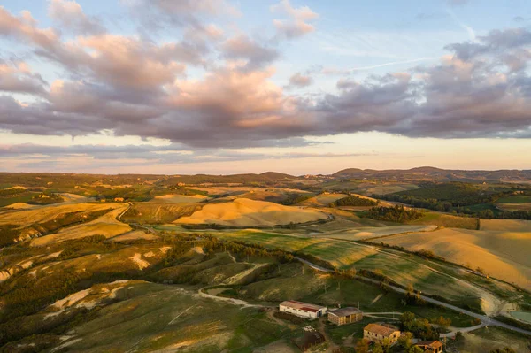 Vista aérea de un paisaje rural al atardecer en Toscana. Granja rural, cipreses, campos verdes, luz solar y nubes. Italia, Europa . —  Fotos de Stock
