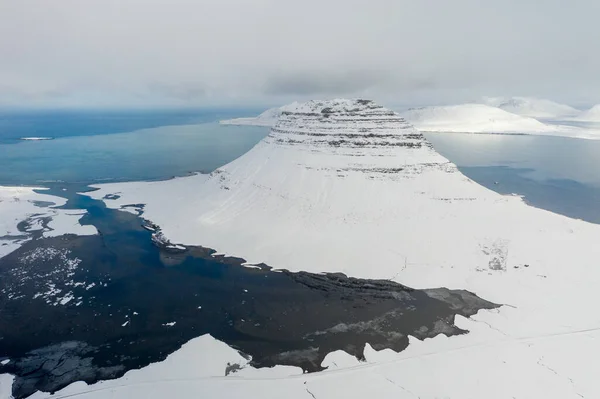Letecký pohled na zasněženou horu Kirkjufell na začátku jara na Islandu. — Stock fotografie