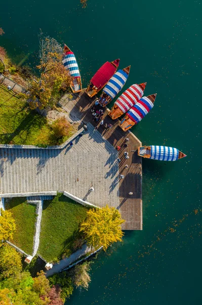 Vista aérea del lago Bled con una pequeña isla con una iglesia y barcos en el muelle. Salida del sol en Eslovenia en otoño . — Foto de Stock
