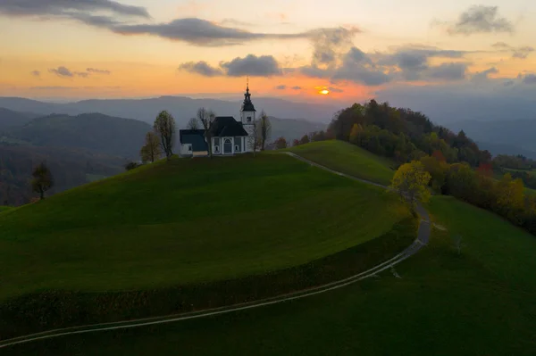Vista aérea das colinas, floresta colorida e a igreja Sv Sobota. Eslovénia pôr do sol no outono — Fotografia de Stock