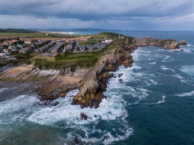 Arnia Sahili 'nde gün batımında kayalıkların ve kayalıkların havadan görünüşü. Kuzey İspanya Yazın