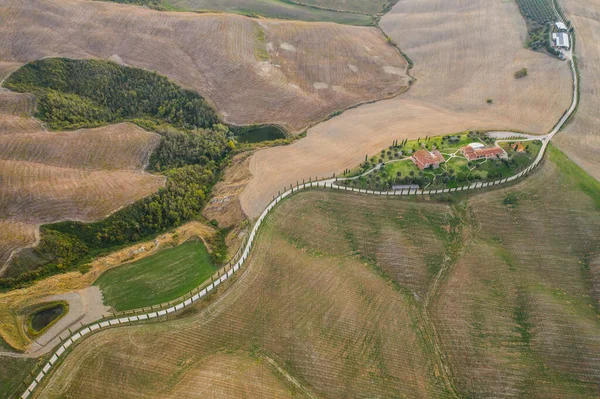Toscana, Val dArbia, Siena 19 de octubre de 2019. Vista aérea de un paisaje rural al atardecer. Granja rural, cipreses, campos verdes, luz solar y nubes. Italia —  Fotos de Stock