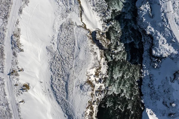 Vista aérea de la cascada Godafoss, la orilla nevada y el río. Islandia a principios de primavera —  Fotos de Stock