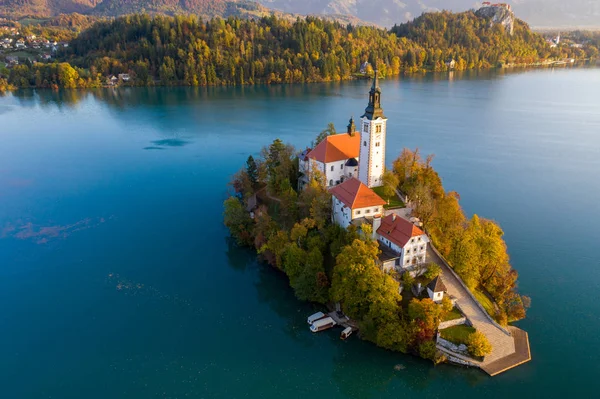 Veduta aerea della foresta colorata e del lago di Bled con una piccola isola con una chiesa. Alba in Slovenia in calo . — Foto Stock
