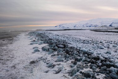 Gün batımında Diamond sahilindeki buz dağlarının ve buz dağlarının havadan görünüşü. İzlanda 'da baharın başlangıcı