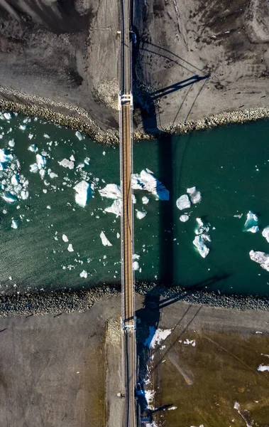 Uitzicht vanuit de lucht op de brug, gletsjerlagune en ijsbergen. IJsland in het vroege voorjaar — Stockfoto