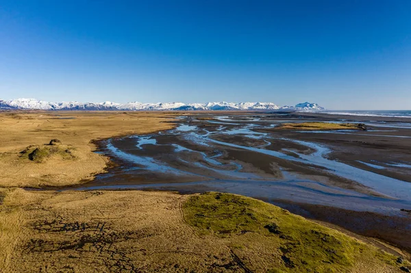 Vzdušný pohled na vzory islandských řek tekoucích do oceánu. Island na začátku jara — Stock fotografie