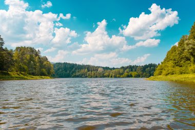 Yeşil sahil ve bulutlar ile nehrin görünümü
