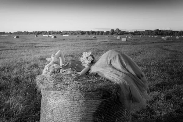 Sexy žena na seno zásobníku na sunset. — Stock fotografie