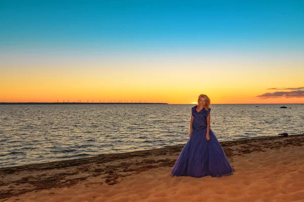 Piękna dziewczyna w jasny fioletowy strój nad morzem. — Zdjęcie stockowe
