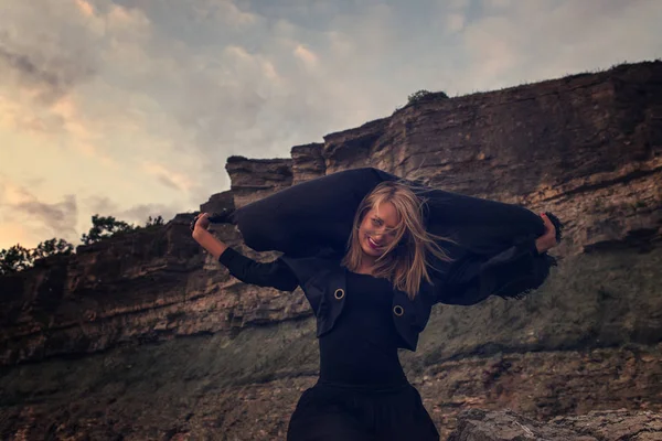 Mujer de negro sobre rocas — Foto de Stock