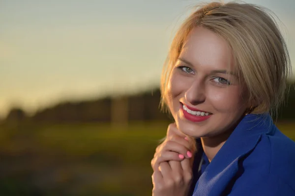 Blond kobieta w niebieski płaszcz portret — Zdjęcie stockowe