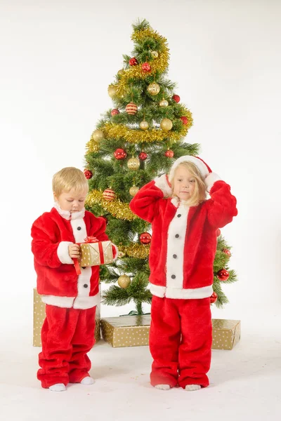 Słodkie dzieci Podziel prezenty świąteczne w pobliżu drzewa — Zdjęcie stockowe