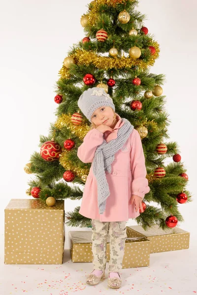 Το μικρό χαριτωμένο κορίτσι που παρουσιάζουν κοντά στο χριστουγεννιάτικο δέντρο — Φωτογραφία Αρχείου