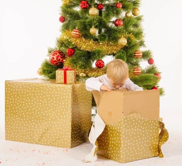 Маленький мальчик открывает коробку подарков — стоковое фото