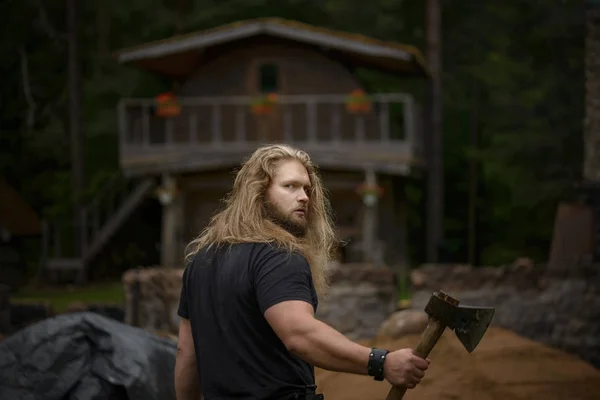Uzun saçlı acımasız adam orman house yakınındaki eksenli — Stok fotoğraf