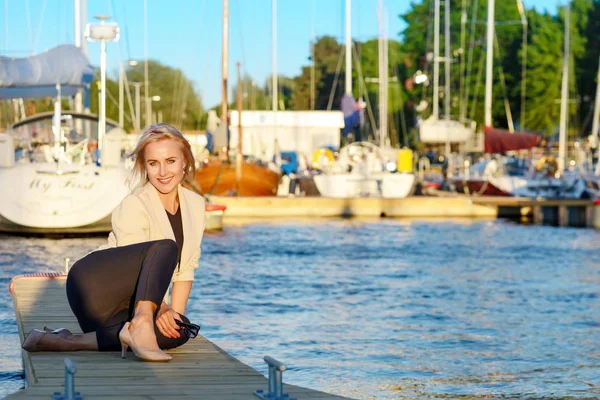 Ділова жінка позує в гавані біля яхт — стокове фото