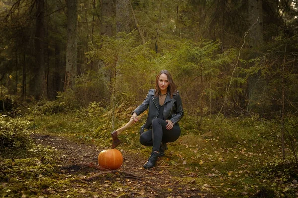 Beauty with ax and pumpkin in a forest — Stock Photo, Image