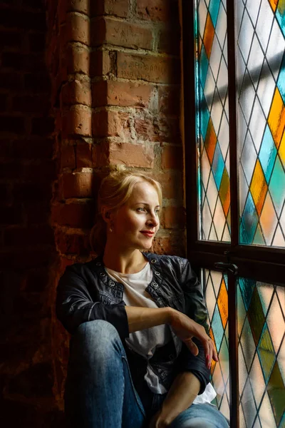 Krásná blondýnka pózuje u mozaikové okno — Stock fotografie