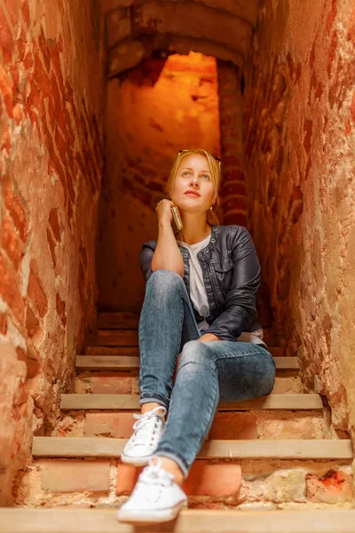 Krásná blondýnka sedí na schodech v Trakai Castle — Stock fotografie