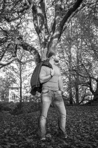 Homem de cabelo longo posando em um parque de outono — Fotografia de Stock