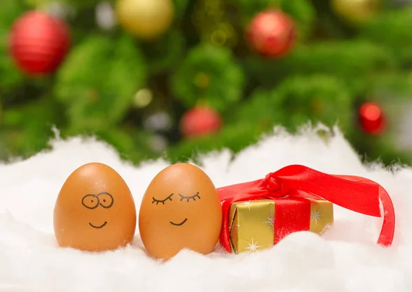 Divertidos huevos encantadores en nieve con caja de regalo —  Fotos de Stock