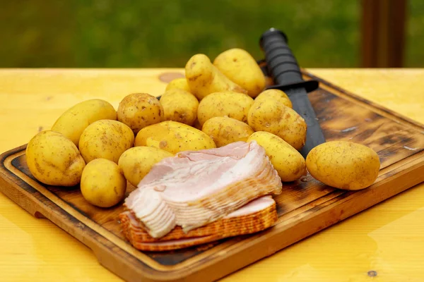 Patatas frescas crudas con carne y cuchillo sobre mesa de madera — Foto de Stock