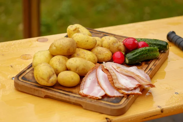 Patate fresche crude con carne e coltello sul tavolo di legno — Foto Stock