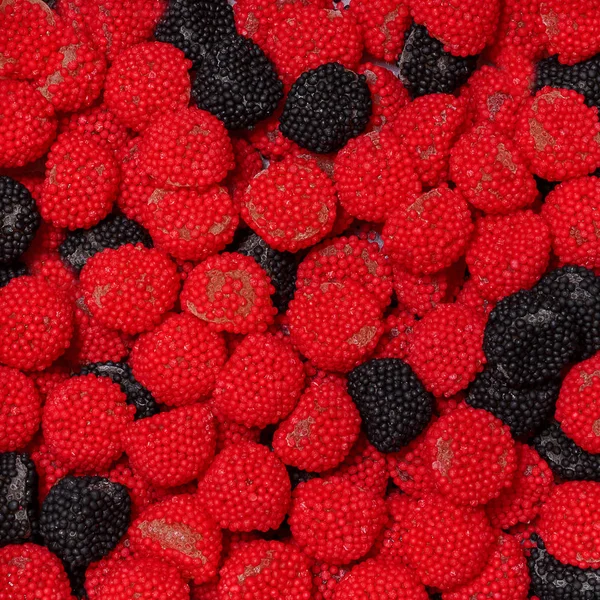 Black and cranberry candies in the form of raspberries and blackberries — Stock Photo, Image