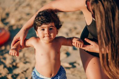 kıyı üzerinde oynarken erkek bebek