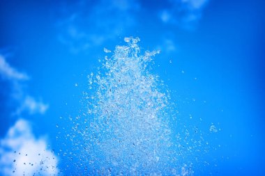 Mavi gökyüzünün arka planında su çeşmesi