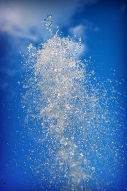 Mavi gökyüzünün arka planında su çeşmesi