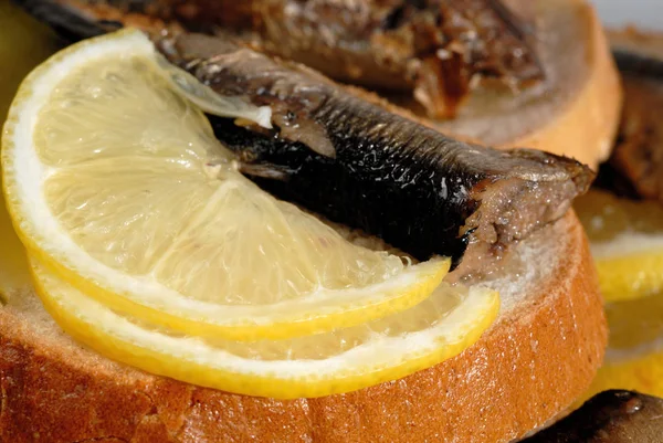 Сэндвич со шпротом и ломтиком лимона крупным планом — стоковое фото