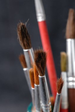 Koyu bir arkaplan önünde resim yapmak için fırçalar. Sığ alan derinliği