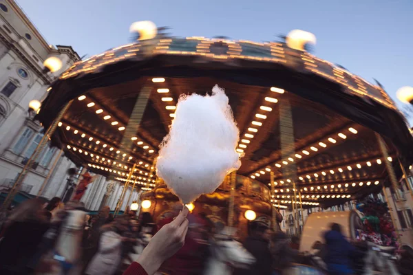 Portrait of a beautiful young girl with white cotton candy in fr