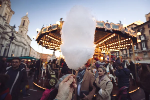 Portrait of a beautiful young girl with white cotton candy in fr