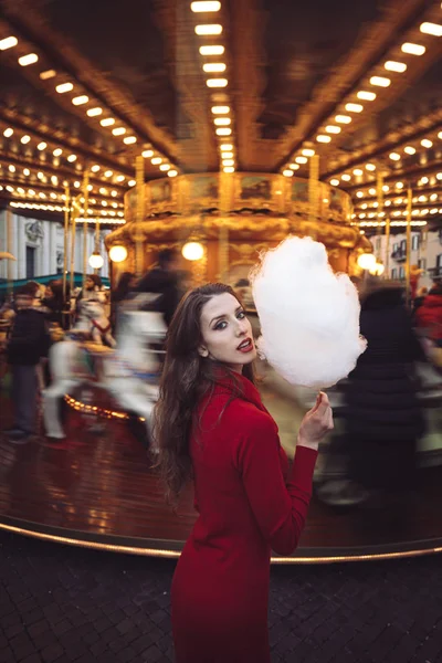 Portrait of a beautiful young girl with white cotton candy in fr