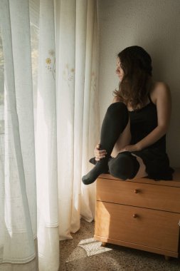 Yatağın yanındaki masada oturan kız