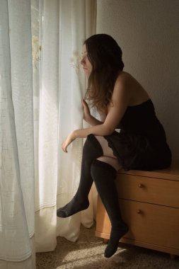 Yatağın yanındaki masada oturan kız