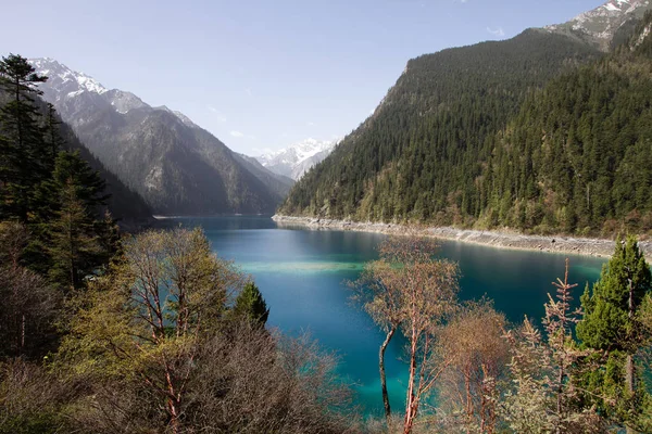 Turkuaz renkli göl Vadisi ormanlar ve mavi gökyüzü ve beyaz bulutlar dağlar.