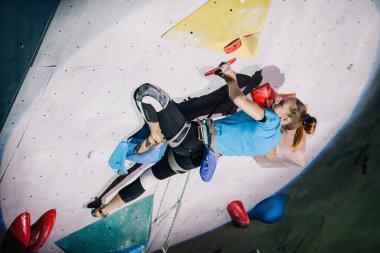Kız yarışmalarda tırmanma duvarına tırmanır.