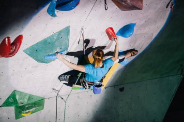 Kız yarışmalarda tırmanma duvarına tırmanır.
