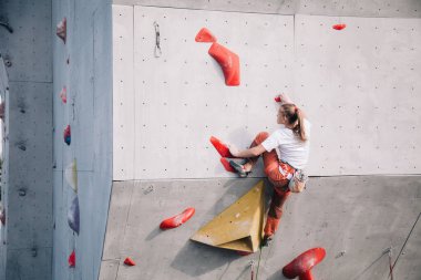 Kız yarışmalarda tırmanma duvarına tırmanır.