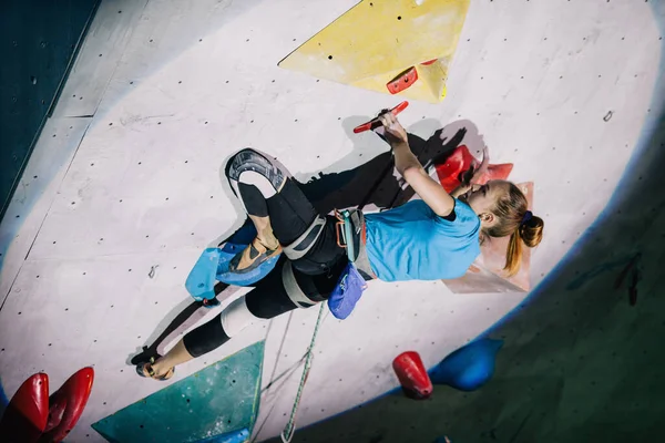 少女は競技会でクライミングウォールに登る — ストック写真