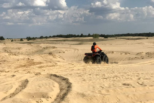 A man riding a quad bike in the desert