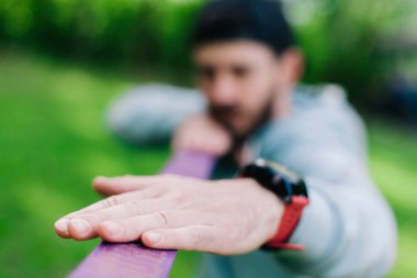 Mavi kapüşonlu genç sakallı adam yürümek için halatı çekti.