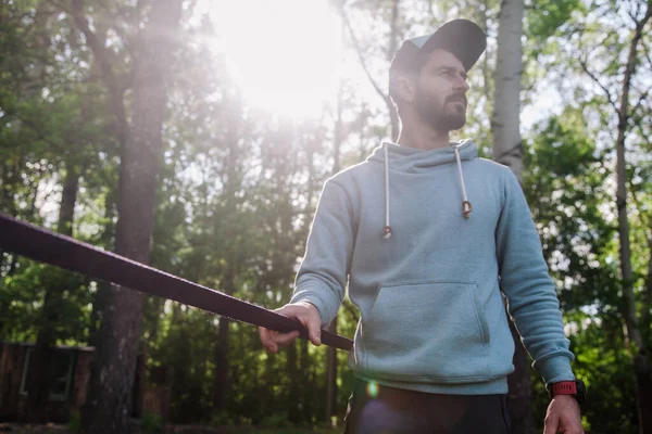 선수에 수염을 남자의 사진이 Slackline 근처의 후드를 — 스톡 사진