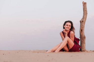 Çölde gün batımında kırmızı elbiseli bir kızın silueti. 