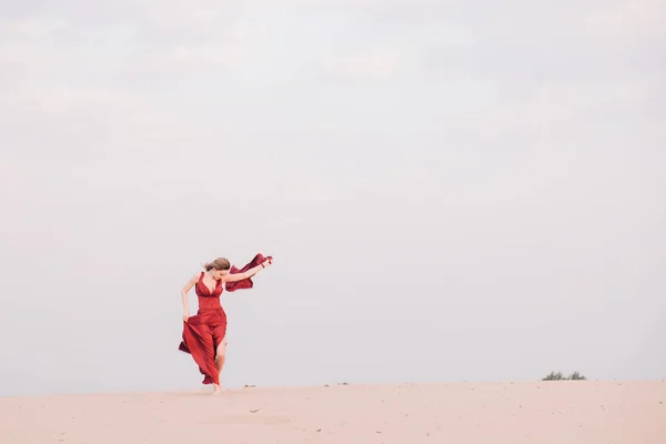 Κορίτσι με κόκκινο φόρεμα το ηλιοβασίλεμα στην έρημο — Φωτογραφία Αρχείου
