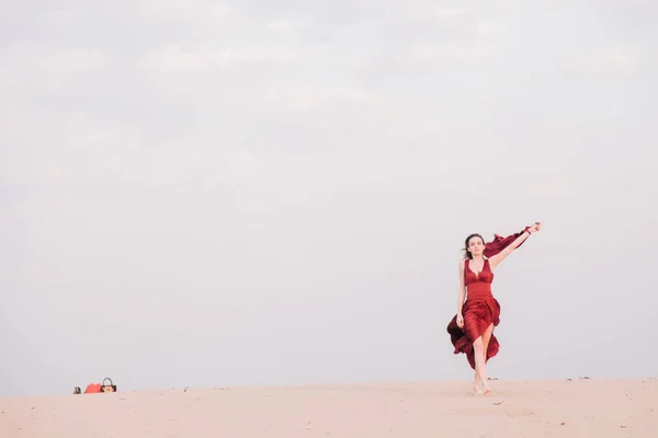 Κορίτσι με κόκκινο φόρεμα το ηλιοβασίλεμα στην έρημο — Φωτογραφία Αρχείου